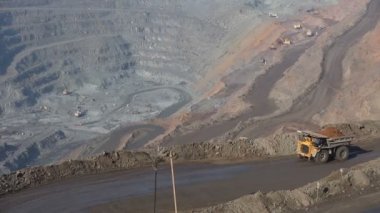 Cevheri ile taş ocağı. İnşaat aletleri. Ekskavatör ve Belaz. Çerçevede Belaz geçer, cevheri ile dolu.