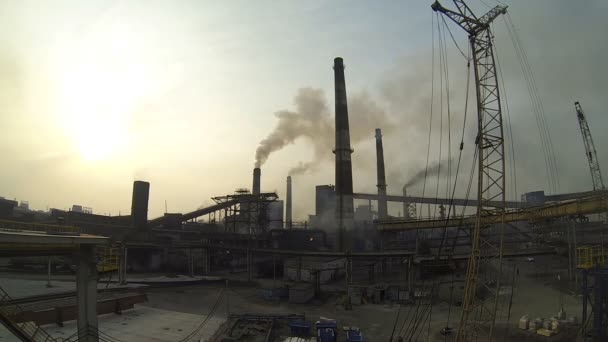 Timelapse del territorio de la planta metalúrgica. De todas las tuberías hay enormes nubes de humo sucio. En el fondo ir trabajador de la planta . — Vídeo de stock