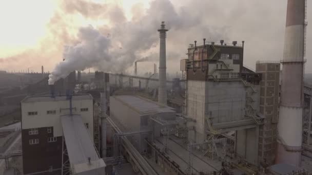 Um drone. Voando sobre a planta metalúrgica. Uma enorme área de tubos sai muita fumaça suja . — Vídeo de Stock