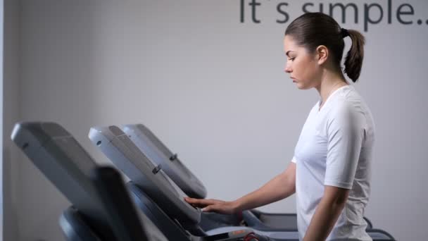 The girl on the treadmill. First comes, accelerates, starts to run. 4K Slow Mo — Stock Video