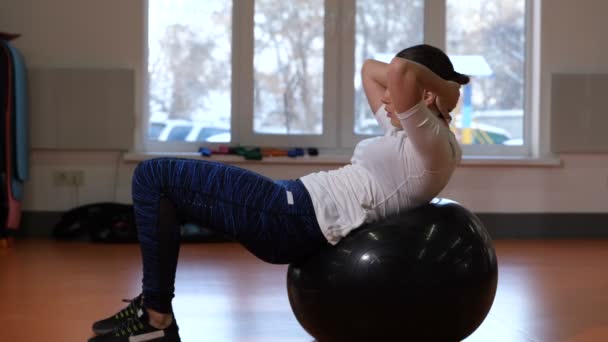 Flicka i fitness-klubben skakar press på bollen. 4 k långsamma Mo — Stockvideo