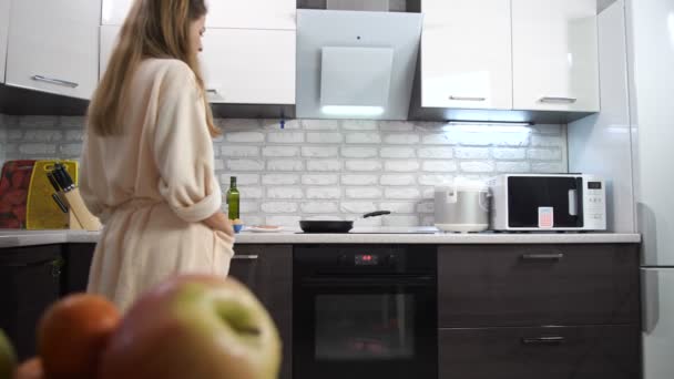 Une femme au foyer endormie en peignoir entre dans la cuisine. Être paresseux pour faire le petit déjeuner est en colère. Mo lent 4K — Video