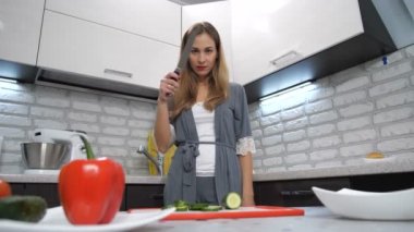 Ev hanımı bir bıçak keskinleştirir. Masaya sebzedir. 4 k yavaş Mo