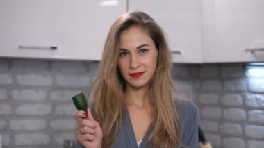 Güzel bir kız portresi. O bir salatalık ve gülümseyerek kameraya ısırır. 4 k yavaş Mo