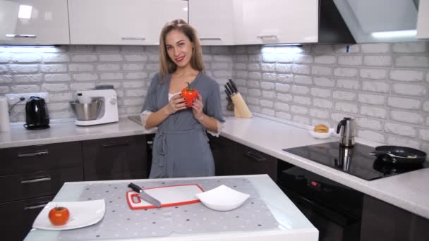 Μια γυναίκα στην σύγχρονη κουζίνα μαζεύει πιπέρι, βάζει την καρδιά και ανοίγει το λαχανικό. Χαμόγελο δίνει τρόπος για να οξυδώσει. Σύμβολο του μια σπασμένη καρδιά. 4 k αργή Mo — Αρχείο Βίντεο