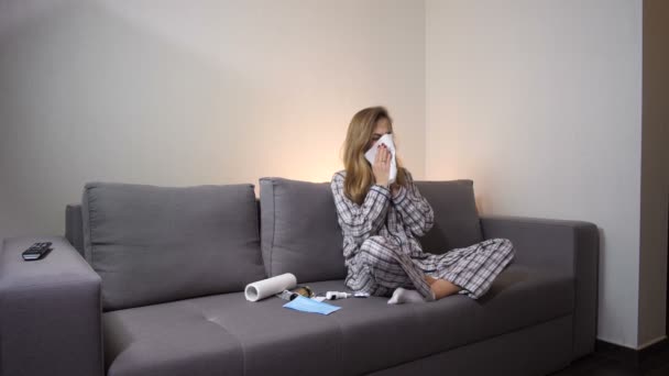 Flickan har en dålig förkylning. Hon blåser näsan i en servett. 4 k långsamma Mo — Stockvideo