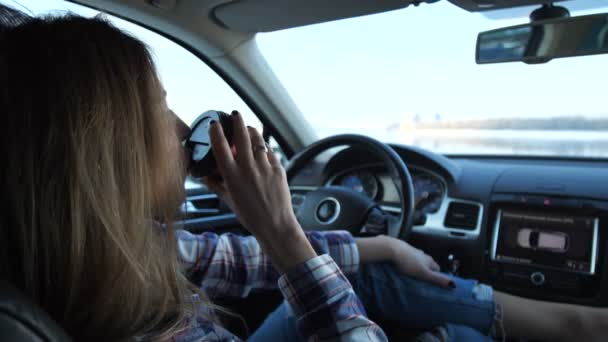 La chica bebe una bebida caliente, mira por la ventana, se relaja en el coche. 4K Slow Mo — Vídeo de stock