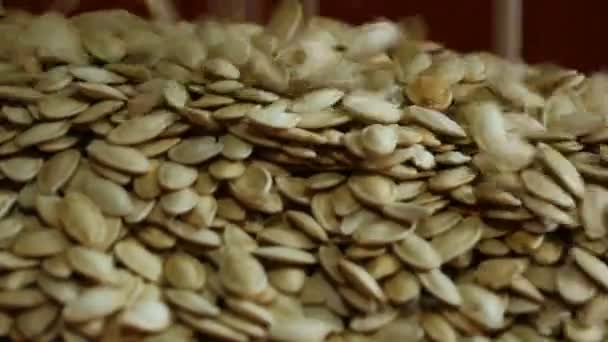 Primo piano, viene versato un mucchio di semi di zucca. . — Video Stock