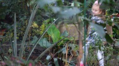 Neşeli kız bahçede ağaçlar arasında atlama. 4 k yavaş Mo