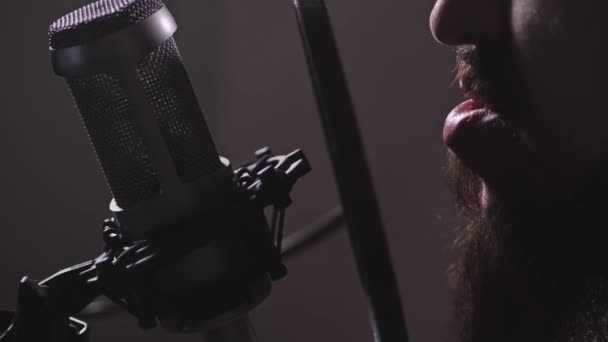 Studio d'enregistrement. Gros plan. Un homme barbu chante une chanson ou lit le texte dans le microphone. Mo lent 4K — Video