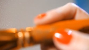 Close. Kadın el boş bir tuval üzerinde mavi boya ile fırça tutar. Resim. 4k yavaş Mo