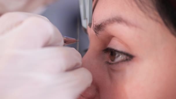Estúdio de beleza. Close-up, um profissional desenha a forma das sobrancelhas para o cliente, antes da maquiagem permanente. 4K Mo lento — Vídeo de Stock