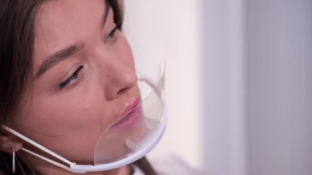 Close-up. Portret van een beautyspecialist in een wit masker. Het meisje is erg gefocust om het werk te doen. 4k slow mo — Stockvideo