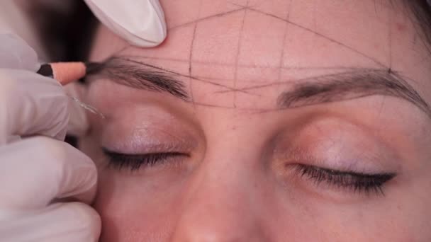 Spécialiste dessiner un croquis des sourcils. Gros plan des formes géométriques claires sur le visage. Mo lent 4K — Video