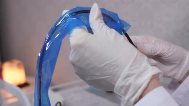 Primer plano. El esteticista prepara la máquina para el maquillaje permanente, le pone una bolsa desechable. 4K Slow Mo — Vídeos de Stock