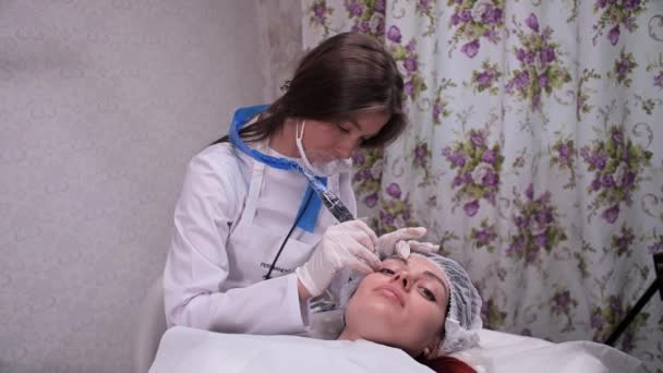 El procedimiento de maquillaje permanente en un salón de belleza. Especialista aplicar pintura con una máquina de escribir en las cejas. 4K Slow Mo — Vídeo de stock