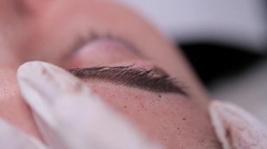 Kaşlarda tüy boyası var. Pigment uygulaması. Yakın çekim, Kalıcı Makyaj. 4k Yavaş Mo
