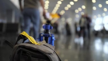 Close. Ön planda bir çanta var, bir adam onu alır ve uzaklaşır. Havaalanı ya da tren istasyonu. 4k Yavaş Mo