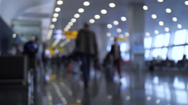 Аэропорт. Люди в дефокусе ходят с сумками и чемоданами. 4K Slow Mo — стоковое видео