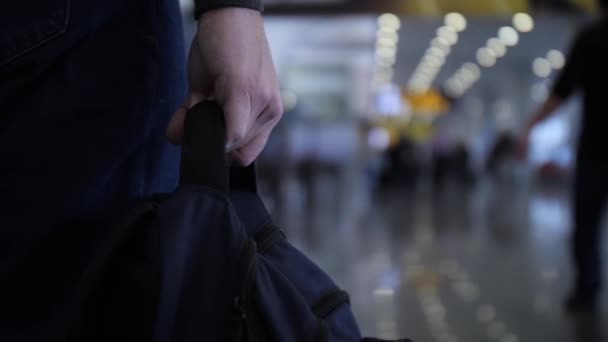 Primer plano. Un hombre lleva una bolsa en la mano. Aeropuerto o estación de tren. 4K Slow Mo — Vídeo de stock
