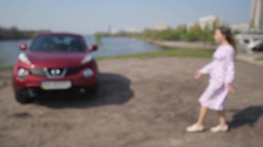 Kız yeni bir araba gördü. Adam anahtarlarını sallıyor, kız onları alır ve arabaya sarılmak için koşar. 4k Yavaş Mo