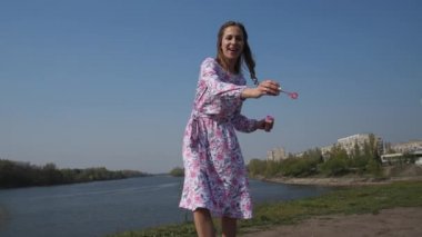 Neşeli genç kadın doğada kabarcıklar üfleme, eğlenmek. 4k Yavaş Mo