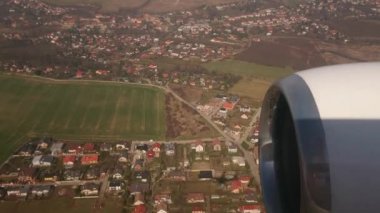 Uçağın penceresinden çok güzel bir video. Uçak gölgesinin altında, şehir ve orman üzerinde uçuş.