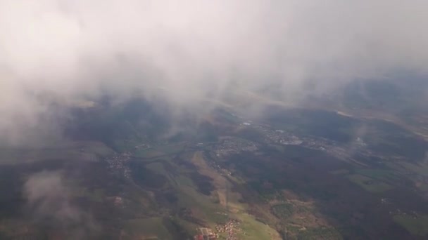 Volando su un aereo in mezzo alle nuvole, il paesaggio è visibile . — Video Stock