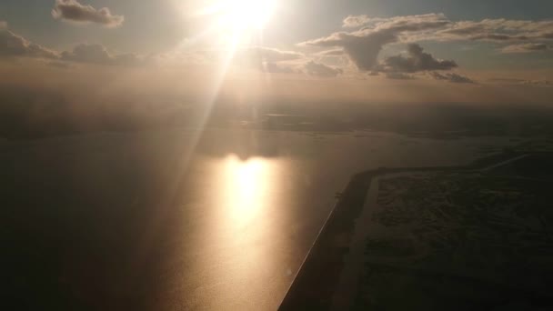 The sun shines frontally into the camera, the river sparkles, the shooting from the cabin of the aircraft. — Stock Video