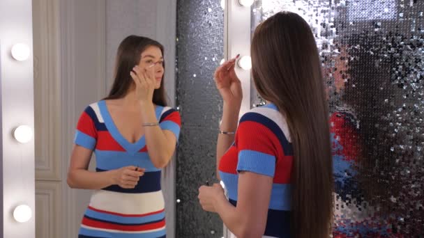 En kvinna gör sin makeup. Svängar och söta leenden. 4k långsam Mo — Stockvideo