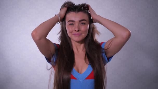 Una ragazza con bei capelli lunghi, guardando nella cornice, poi rimuove i capelli indietro e sorride. 4K Lento Lu — Video Stock