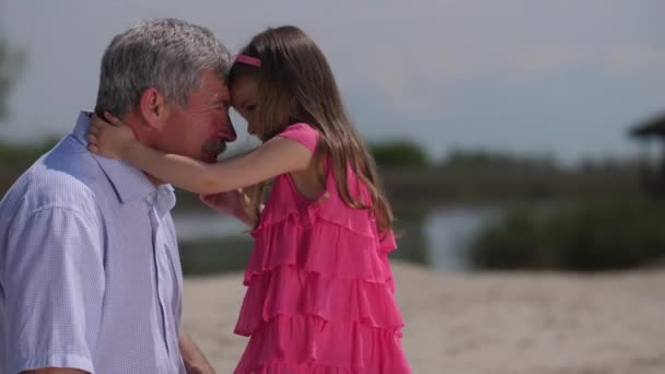孫娘は額に祖父の額に行き、抱きしめて微笑む。4k スローモー — ストック動画