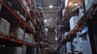 Büyük bir lojistik depo. Kutuları ile yüksek raflar boyunca kamera hareketi. 4k Yavaş Mo