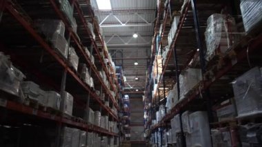 Lojistik deposu. Ürünlerle raflar. Raflarda bir sürü kutu var. Kamera hareket halinde. 4k Yavaş Mo