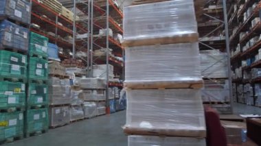 Büyük bir lojistik depo. Raflı satırlar arasındaki panorama. Ambar kutularda ürünlerle doldurulur. 4k Yavaş Mo
