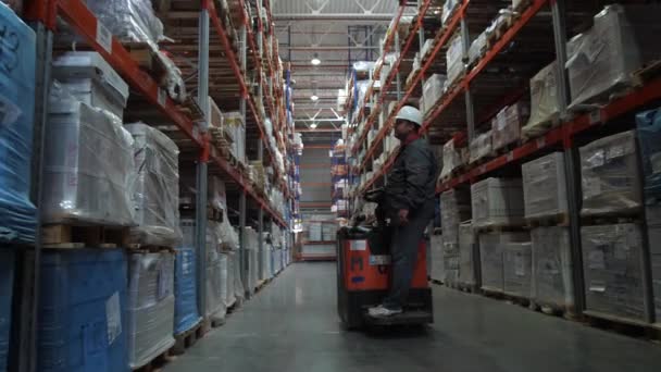 Ongelooflijk groot logistiek magazijn. Een man op een auto passeert de camera. 4k slow mo — Stockvideo