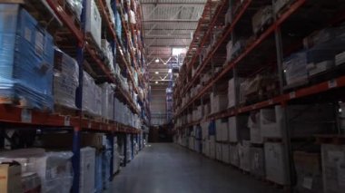 Lojistik deposunun panoraması. Mal ile yüksek sıralar boyunca kameranın geçişi. 4k Yavaş Mo