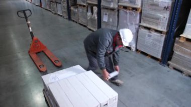 İşçi plastik şal ile mal ile bir palet paketleri. 4k Yavaş Mo