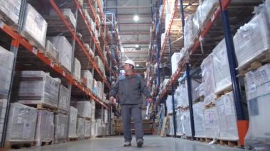Yükleyici büyük bir depoda, genel plan, hareket kamera. 4k Yavaş Mo