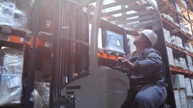 Lojistik depo, forklift yüksek raf ve yaprakları mal ile paletkaldırır. 4k Yavaş Mo