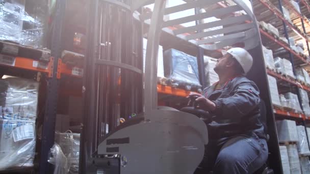 Logistiek magazijn, heftruck verwijdert pallets met goederen uit een hoge plank en bladeren. 4k slow mo — Stockvideo