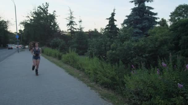 특별한 신발을 신은 소녀 강구 점프가 공원의 길을 따라 달리고 있습니다. 4k 슬로우 모 — 비디오