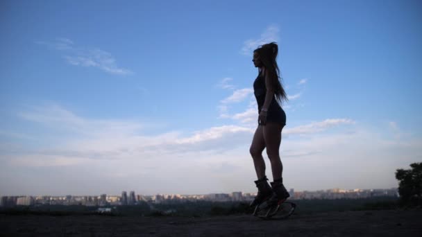 Mooie silhouet video. Meisje is dansen in angoo springt laarzen tegen de hemel. 4k slow mo — Stockvideo