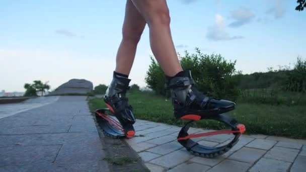 Gros plan des jambes des femmes en chaussures de saut angoo. Une femme descend la rue. Mo lent 4K — Video