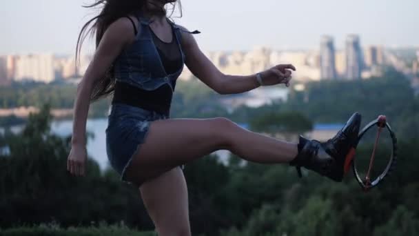 Vacker kvinna med långt hår hoppar på bakgrunden av staden i Kangoo hoppar skor. 4K långsam Mo — Stockvideo