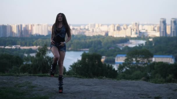 Beautiful woman dancing against the background of the city in Kangoo jumps shoes. 4K Slow Mo — Stock Video