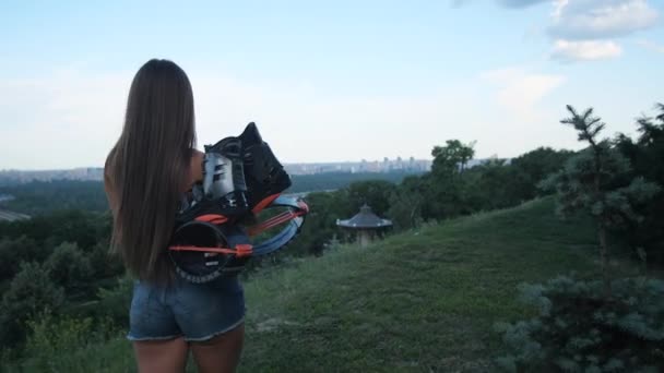A girl with long brown hair goes to work angoo jumps. She has specialized shoes in her hands. 4K Slow Mo — Stock Video