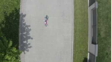 Havadan vurulan küçük kız, parkta ya da kulübede bisiklete biniyor. 4k Yavaş Mo