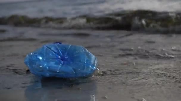 Yakın plan. Çevre kirliliği. Plastik bir şişe deniz kıyısında yüzer. 4k Ağır çekim — Stok video