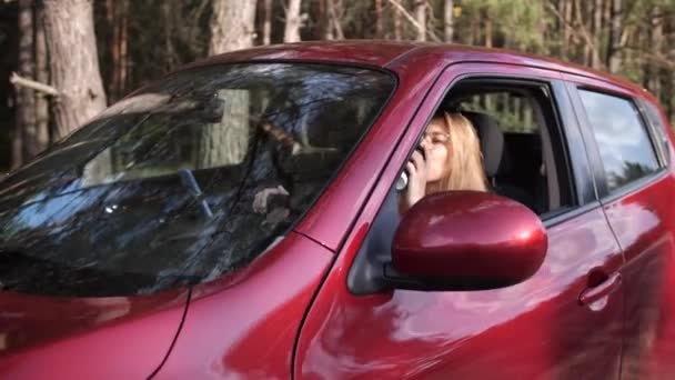 A lány sofőr bedobott egy csésze kávét az ablakon. Környezetszennyezés. — Stock videók